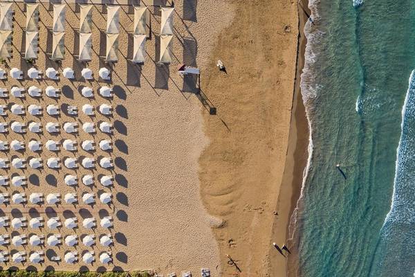 Luftaufnahme des TUI BLUE Side Hotels mit vielen Sonnenschirmen am Strand und Personen im Wasser.