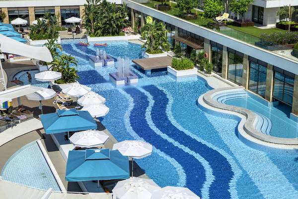 Luftaufnahme des TUI BLUE Side Pools mit Wasserfontaene und Sonnenschirmen