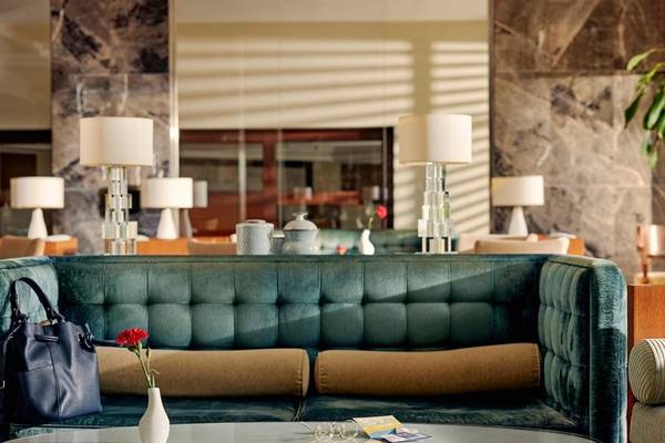 Lobby des TUI BLUE Side Hotels mit grünem Sofa, Tisch und Blumenvase.