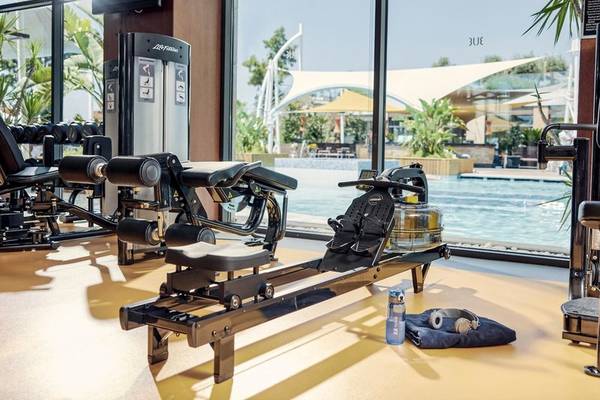 Fitnessstudio im Hotel TUI BLUE Side mit Blick auf den Pool und Trainingsgeräten.