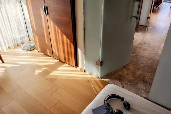 Innenbereich des TUI BLUE Side Hotels mit geräumigem Zimmer, Holzboden, offenem Schrank und Fenstern.