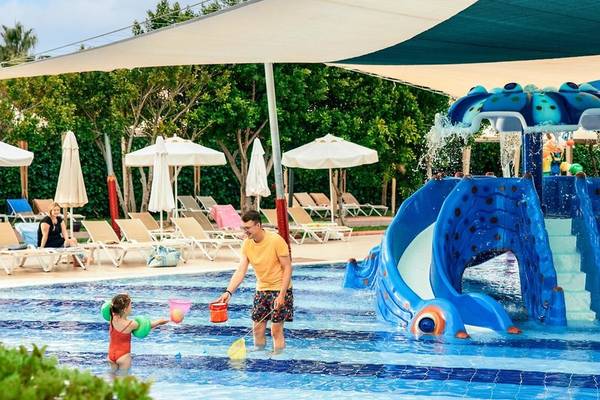 Mann und Kind spielen im Wasser am Pool im Magic Life Jacaranda Hotel