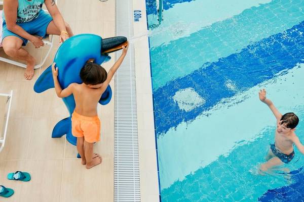 Vater und Kinder am Schwimmbad von Magic Life Jacaranda Hotel