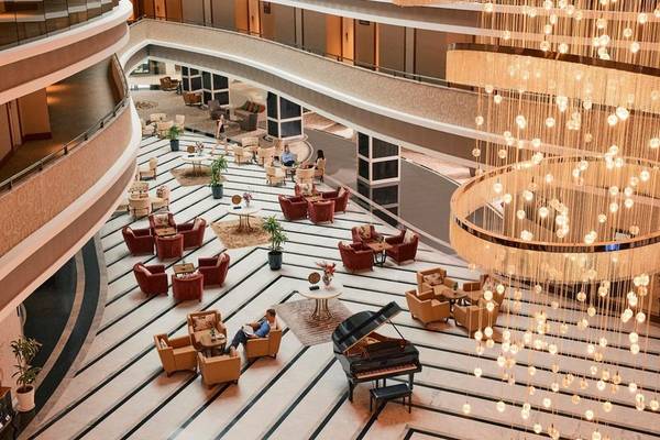Hotellobby des Magic Life Jacaranda mit Klavier, Kristallleuchte und Loungemöbeln.