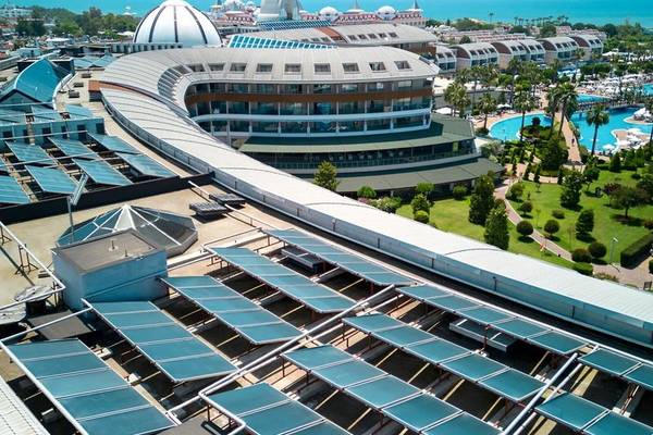 Luftaufnahme des Magic Life Jacaranda Hotels mit Solarpaneelen, Gebäuden und Swimmingpools am Meer.