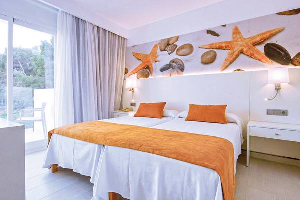 Doppelzimmer im Calimera Balansat Resort mit Sternenfisch-Tapete und Fensterblick auf Bäume.