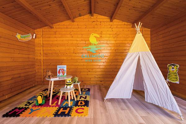 Kinderspielzimmer im Calimero Balansat Resort mit buntem Teppich, Spielsachen und Tipi.