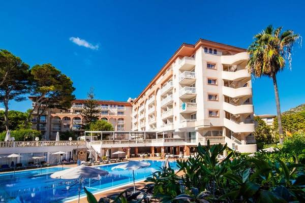 Außenansicht des Canyamel Classic Hotels mit Pool und Sonnenschirmen.