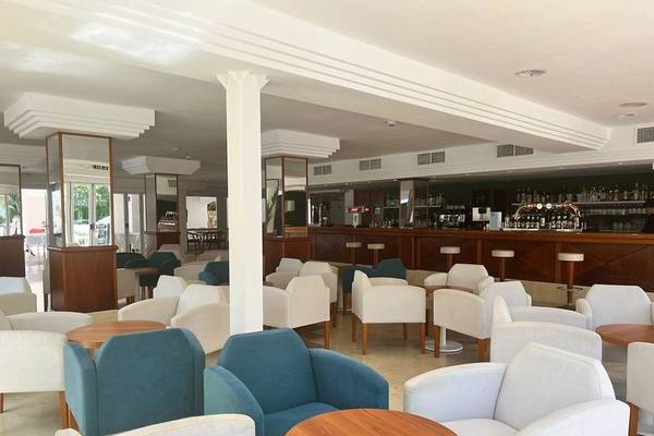 Loungebereich des Canyamel Classic Hotels mit vielen weißen und blauen Stühlen und Tischen.