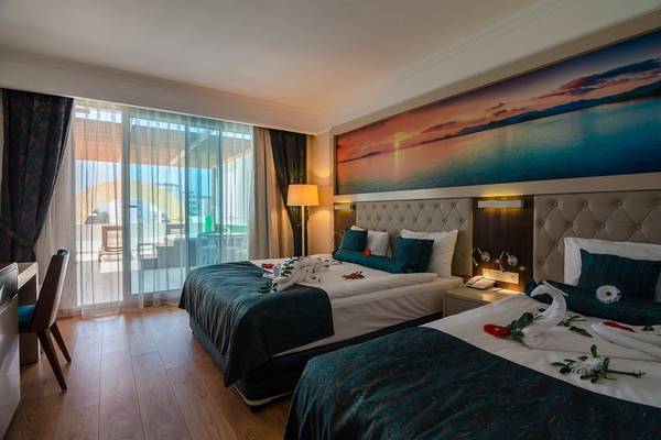 Doppelbett im Lumos Deluxe Resort Hotel & Spa mit Blick auf eine malerische Landschaft.