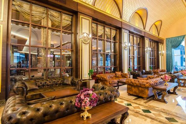Empfangsbereich des Lumos Deluxe Resort Hotel & Spa mit Ledersofas und Blumenarrangements