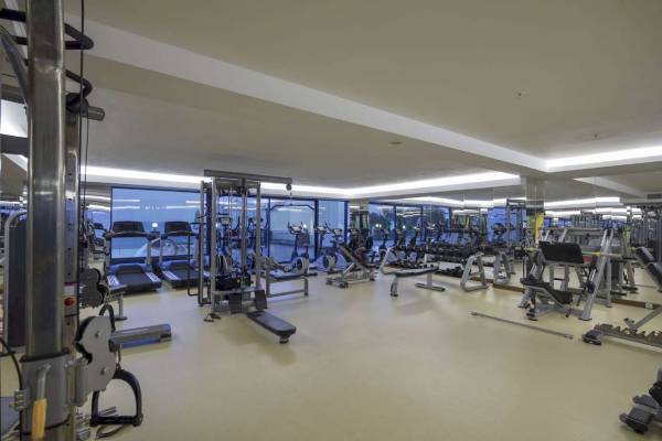Fitnesscenter im Hotel Granada Luxury Okurcalar mit vielen Trainingsgeräten und großen Fenstern