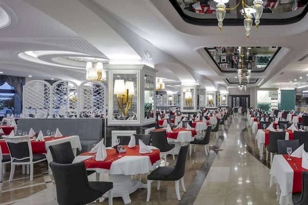 Innenansicht des Restaurants im Hotel Granada Luxury Okurcalar mit vielen gedeckten Tischen und Stühlen.