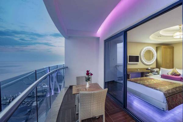 Suite im Hotel Granada Luxury Okurcalar mit Blick auf das Meer und einem Tisch mit Rosen.