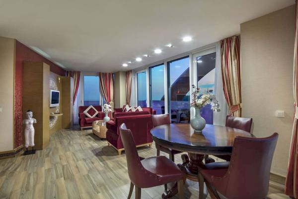 Innenansicht der Suite im Granada Luxury Okurcalar Hotel mit Möbeln und Panoramafenstern.
