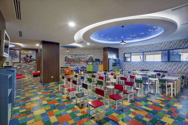Kinderzimmer im Granada Luxury Hotel Okurcalar mit bunten Teppichfliesen und farbenfrohen Stühlen.