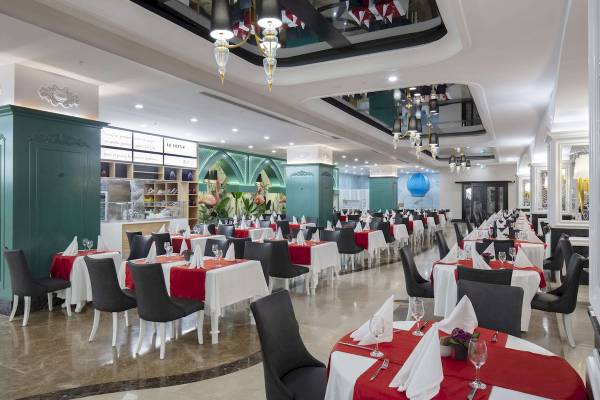 Innenansicht des Restaurants im Granada Luxury Okurcalar Hotel mit vielen gedeckten Tischen.