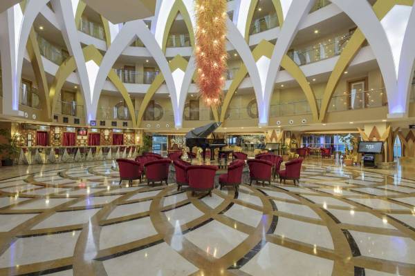 Lobby des Granada Luxury Okurcalar Hotels mit Klavier und roten Stühlen