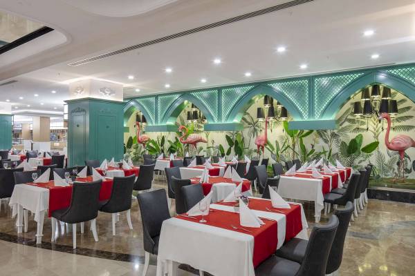 Innenbereich eines Restaurants im Hotel Granada Luxury Okurcalar mit tropischen Flamingo-Wandmalereien.