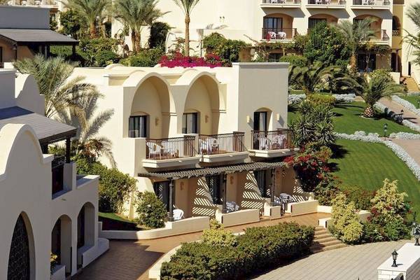 Außenansicht des Jaz Belvedere Resorts mit mehreren Gebäuden und Terrassen, umgeben von Gärten und Palmen.