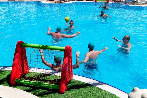 Gruppe von Männern spielt Wasserball im Pool des Granada Luxury Hotels.