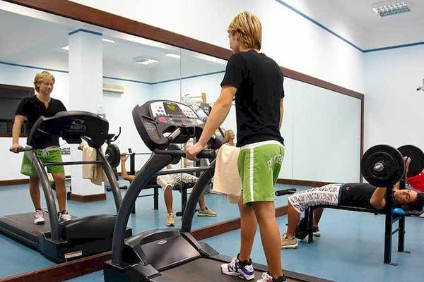 Fitnessstudio im Jaz Belvedere Resort mit Personen, die auf Laufband und Hantelbank trainieren.