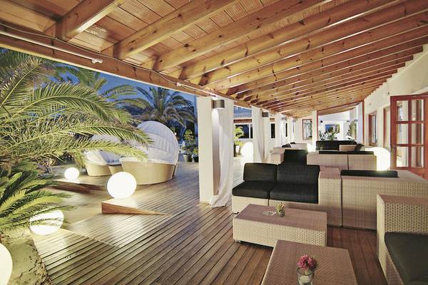 Loungebereich im Tahiti Hotel mit Holzboden, weißen Kissen und Laternen.