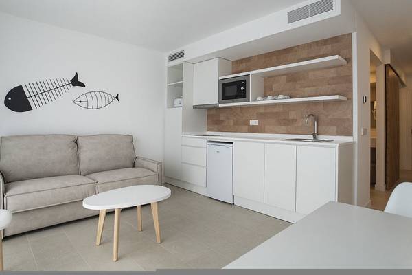 Modernes Hotelzimmer mit Wohnzimmerbereich und integrierter Küche.