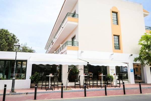 Außenansicht des Rosales Formentera Hotels mit Terrasse und Tischen.
