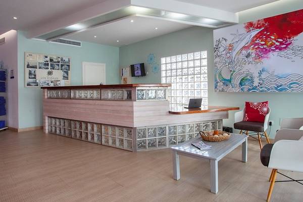 Rezeptionsbereich des Rosales Formentera Hotels mit modernem Design und bunten Wandmalereien.
