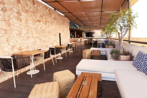 Terrasse des Castavi Hotels mit Tischen, Stühlen und Sofas.