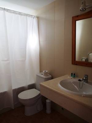 Badezimmer im Roca Plana Hotel mit WC, Waschbecken und Spiegel