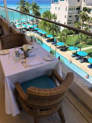 Tisch auf dem Balkon des Sands Barbados Hotels mit Blick auf den Pool und das Meer.