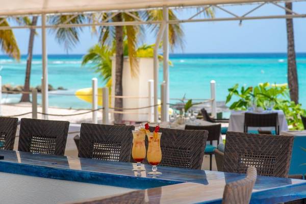 Strandbar im Sands Barbados Hotel mit Blick auf das Meer und Cocktails auf dem Tresen.