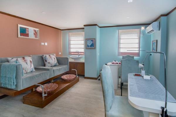 Innenbereich des Spa-Behandlungsraums im Hotel The Sands Barbados mit Sofa, Schreibtisch und Waschbecken.