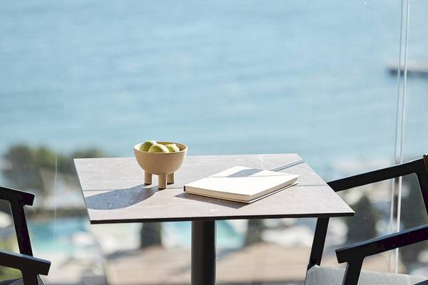 Tisch mit Buch und Obst am Meer im Helea Lifestyle Beach Resort
