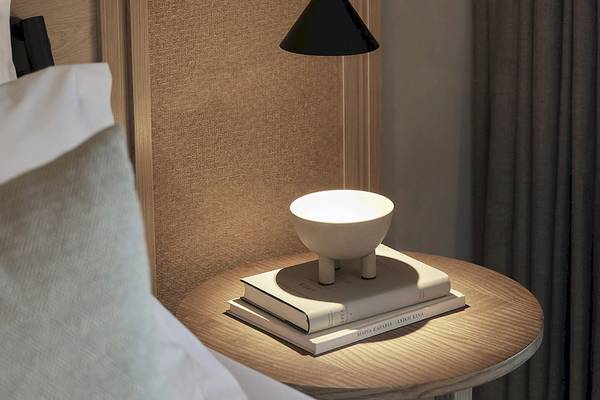 Nachttisch mit Lampe und Büchern im Zimmer des Helea Lifestyle Beach Resort