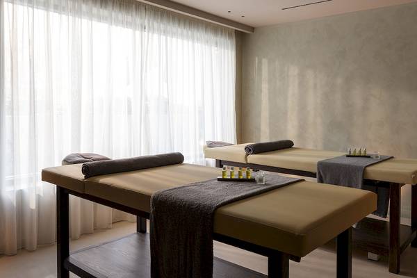 Massagebereich im Helea Lifestyle Beach Resort mit zwei Massageliegen nebeneinander und einer weißen Vorhang.