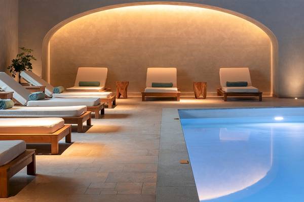 Loungebereich im Helea Lifestyle Beach Resort mit weißen Liegen und einem Pool.