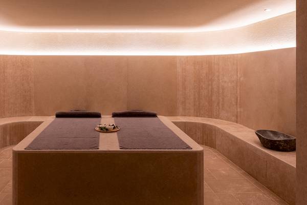 Massageraum im Helea Lifestyle Beach Resort mit zwei Liegen und dekorativen Elementen.