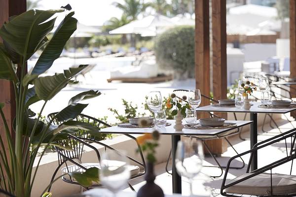 Außenbereich des Helea Lifestyle Beach Resorts mit Tisch und Stühlen im Freien.