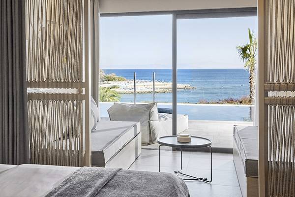 Zimmer im Helea Lifestyle Beach Resort mit Meerblick, inklusive Bett, Tisch, und Aussicht auf den Ozean.