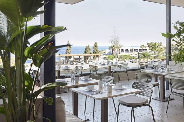 Innenansicht des Restaurants im Helea Lifestyle Beach Resort mit Blick auf das Meer und den Garten.