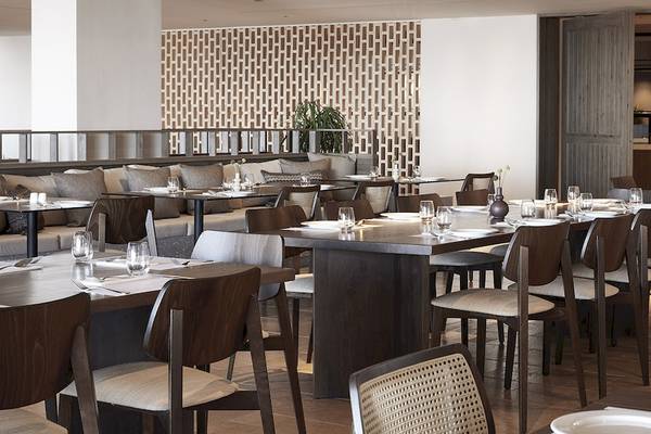 Innenansicht des Restaurants im Helea Lifestyle Beach Resort mit eingerichteten Tischen und Stühlen.
