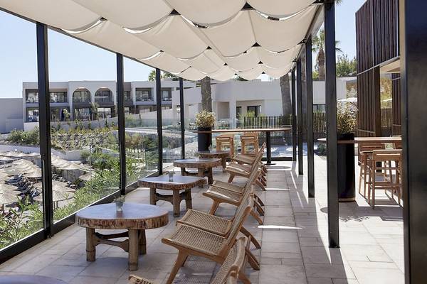 Terrasse im Helea Lifestyle Beach Resort mit Blick auf einen Pool und eine tropische Landschaft