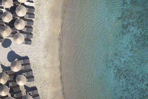 Luftaufnahme des Helea Lifestyle Beach Resorts mit Sonnenliegen und kristallklarem Wasser
