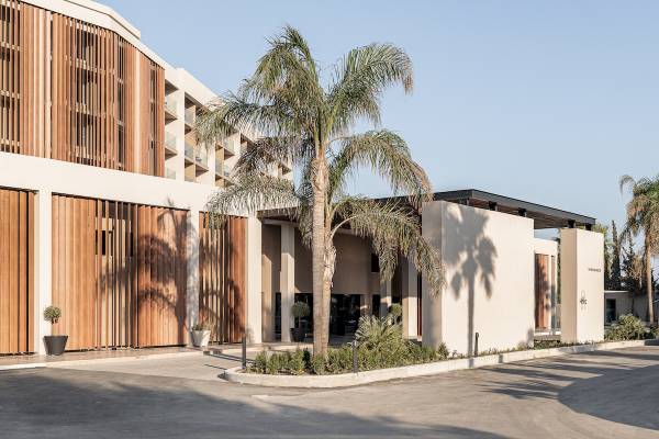 Außenansicht des Helea Lifestyle Beach Resorts mit Eingang, Palmen und modernem Design.