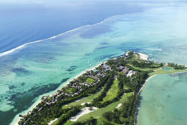 Luftaufnahme des Paradis Beachcomber Golf Resort & Spa mit blauem Ozean, weißem Sandstrand und Golfplatz