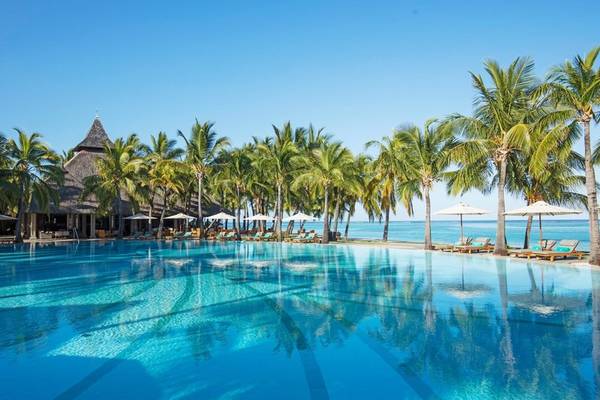 Pool im Paradis Beachcomber Golf Resort & Spa mit Palmen und Sonnenliegen