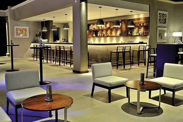 Innenansicht der Bar im Paradis Beachcomber Golf Resort & Spa mit Holztheke und modernen Möbeln
